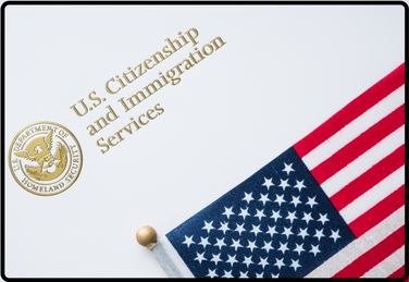 white background with portion of American flag and words 'U.S. Citizenship and Immigration Services' along with US Dept of Homeland Security seal
