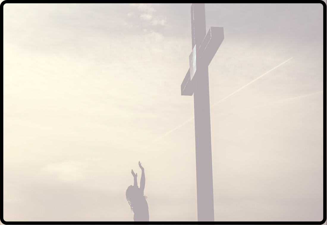 Woman with lifted hands toward a tall dark cross against a cloudy sky