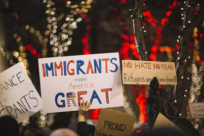 Picture of protestors with signs about immigrations and refugees being welcome in America